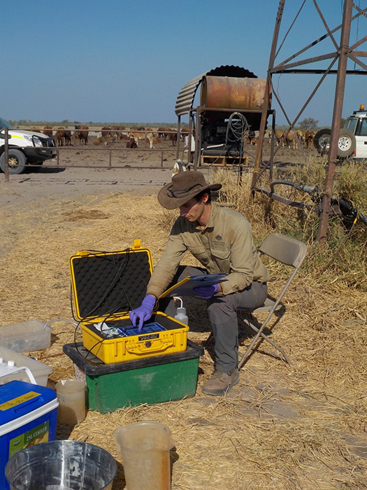 A man is siting with testing equipment in the Northern Territory