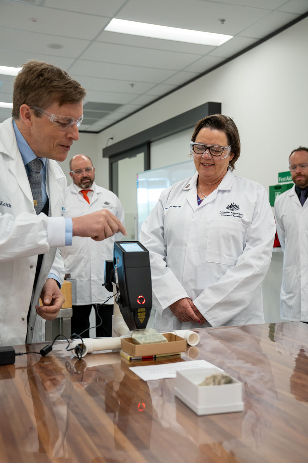 Dr Keith Sircombe explaining to Minister Madeleine King MP how to operate the Portable Laser Induced Breakdown Spectroscopy equipment, which was used to analyse a spodumene sample from Western Australia