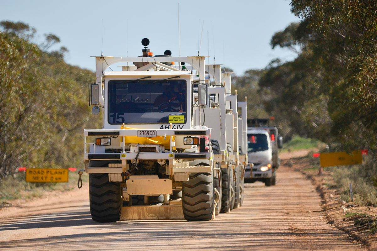 Vibroseis trucks driving on a dirt road